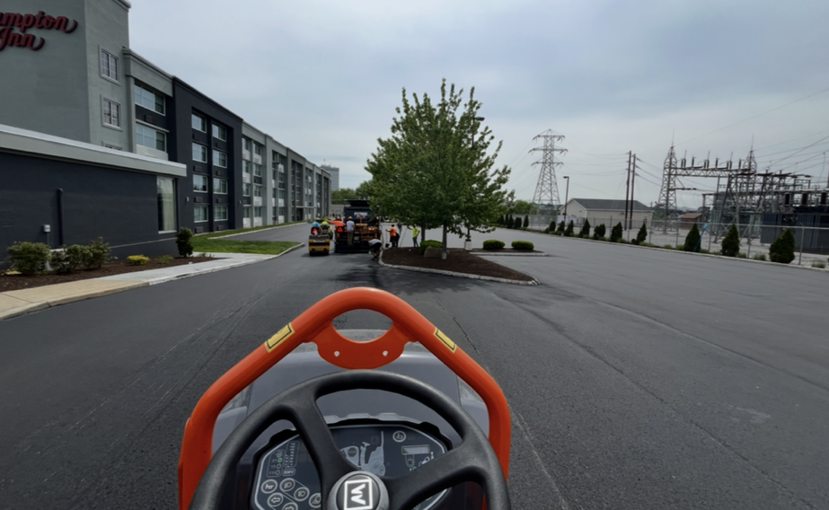 Freshly paved curved driveway winding up to a house