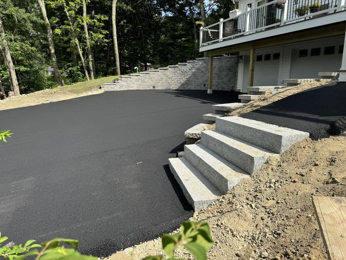 Paver walkway installed alongside a paved driveway